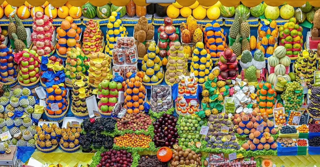 Banca de frutas empilhadas em cores variadas no Mercado Municipal de São Paulo