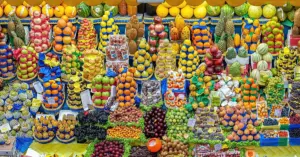 Banca de frutas empilhadas em cores variadas no Mercado Municipal de São Paulo