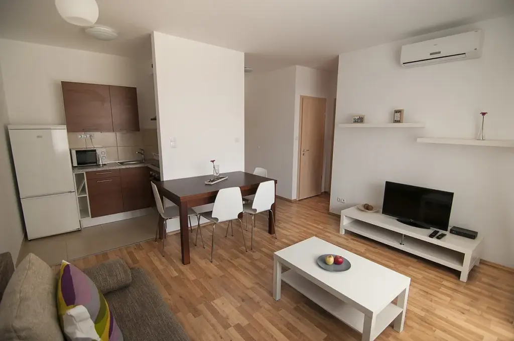 Apartamento pequeno com sala e cozinha integradas, mesa, sofá e televisor