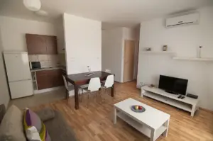 Apartamento pequeno com sala e cozinha integradas, mesa, sofá e televisor