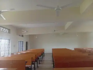 Sala de aula vazia com fileiras de carteiras de madeira