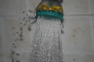 Jato de água saindo de um chuveiro, com as gotas congeladas pela câmera