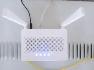 Roteador de Wi-Fi branco com duas antenas e luzes azuis acesas, com os cabos ligados
