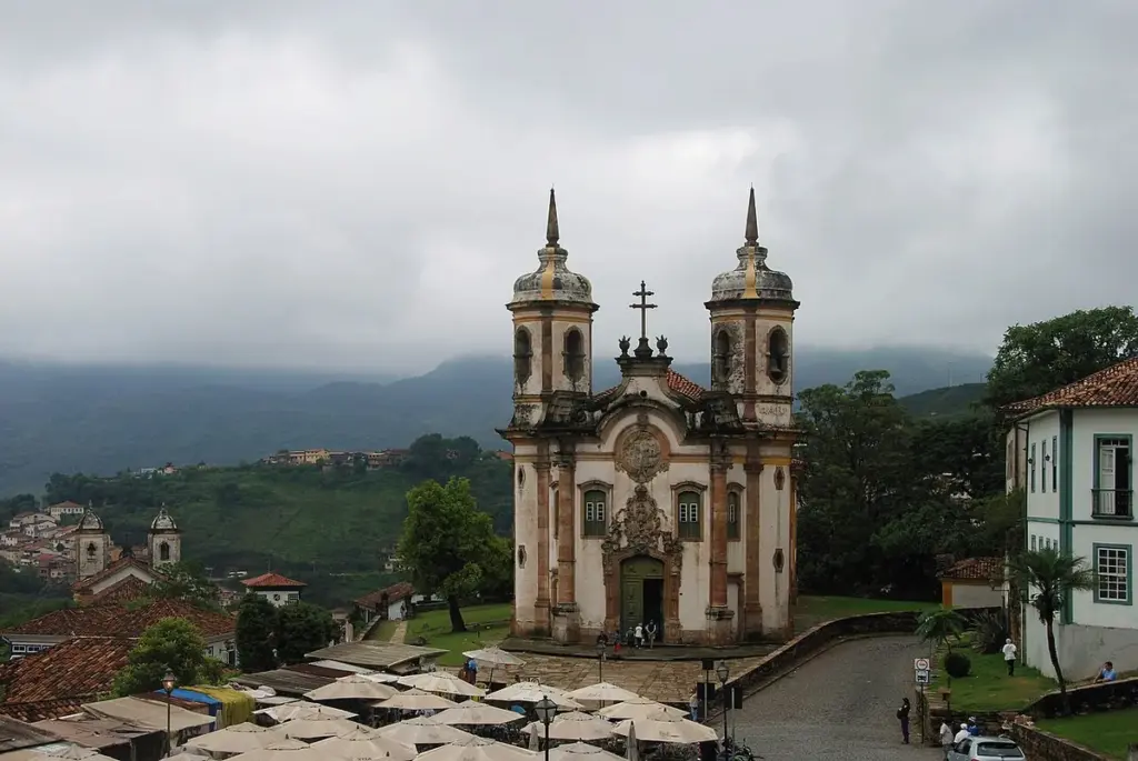 Igreja de São Francisco de Assis, em Ouro Preto, com casario e morros ao fundo em dia nublado