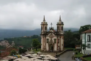 Igreja de São Francisco de Assis, em Ouro Preto, com casario e morros ao fundo em dia nublado