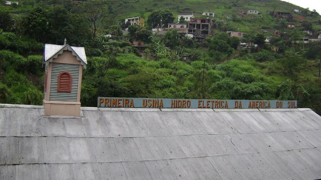 Cobertura e torre da Usina de Marmelos em Juiz de Fora, com letreiro histórico e encosta ao fundo, em fotografia de 2007